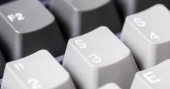 Close-up of grey computer keyboard with symbols.